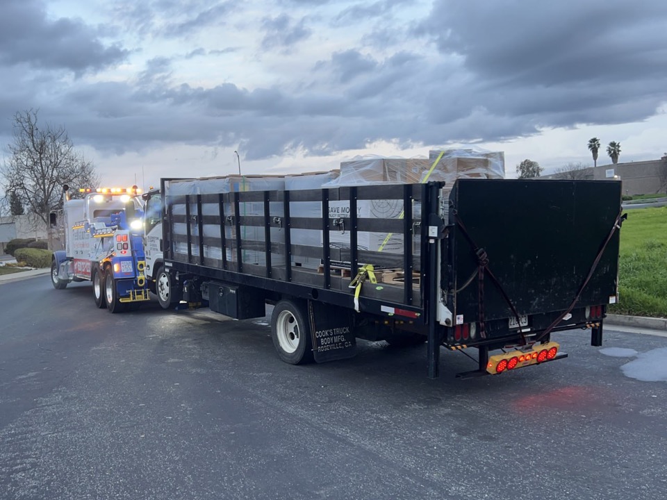 Fleet Nation heavy duty tow truck hauling a loaded flatbed